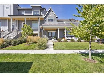 Beautiful gray home with a manicured lawn and covered front porch, perfect for relaxing outdoors at 397 East St, Louisville, CO 80027