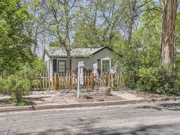 Charming home featuring a white picket fence and mature trees, offering curb appeal and privacy at 6047 S Hill St, Littleton, CO 80120