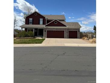 Charming two-story home with a three car garage, well-maintained lawn, and manicured landscaping at 20670 Bridlewood Ln, Parker, CO 80138