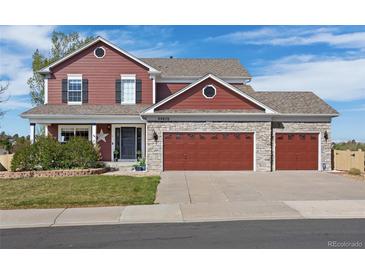 Charming two-story home featuring a three-car garage and well-maintained landscaping at 20670 Bridlewood Ln, Parker, CO 80138