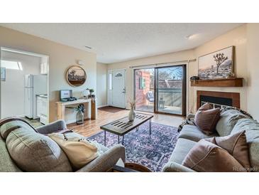 Cozy living room featuring stylish furniture, fireplace and sliding door access to the outside at 3050 W 32Nd Ave # 202C, Denver, CO 80211