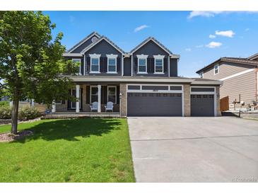 Beautiful two-story home featuring a three car garage, manicured lawn, and charming curb appeal at 19653 E Ida Dr, Aurora, CO 80015