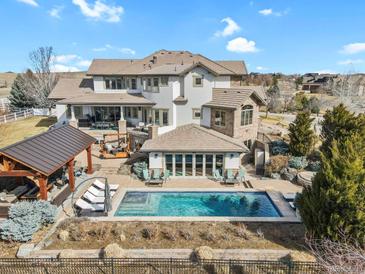 Stunning backyard featuring a pool, outdoor kitchen, and lounge area perfect for entertaining and relaxation at 2960 High Prairie Way, Broomfield, CO 80023