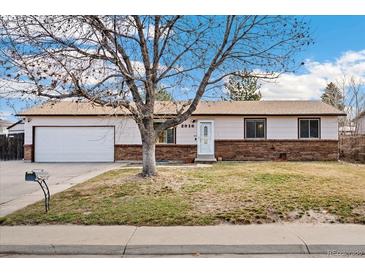 Charming single-story home featuring a brick facade, attached garage, and mature tree in the front yard at 2916 S Jasper St, Aurora, CO 80013