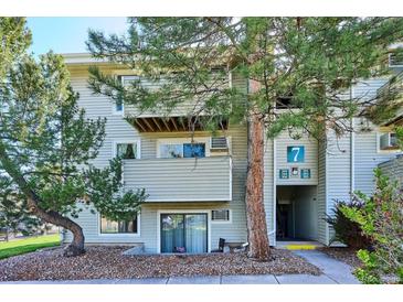 Exterior of a multi-story residential building with well-maintained landscaping and visible unit entrances at 10150 E Virginia Ave # 7-204, Denver, CO 80247