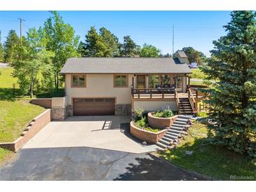 Charming home with a two-car garage, deck, and landscaped front yard at 713 Aspen Rd, Golden, CO 80401