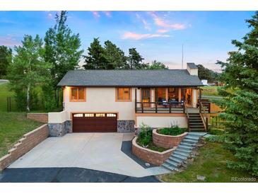 Charming home featuring a two-car garage, a welcoming porch, and landscaped steps to the entry way at 713 Aspen Rd, Golden, CO 80401