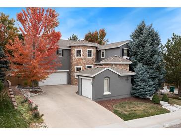 Charming home showcasing a stone turret, mature trees, and a well-maintained lawn at 2832 Danbury Ave, Highlands Ranch, CO 80126