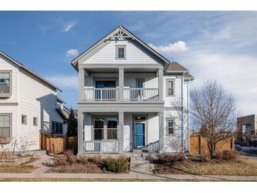 Two-story home with gray siding, balcony, and landscaped front yard at 4942 Wabash St, Denver, CO 80238