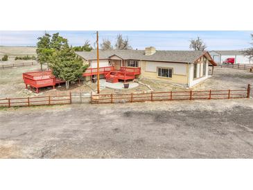Ranch-style home featuring a spacious deck and a fenced yard, perfect for outdoor living at 1632 S County Road 137, Bennett, CO 80102