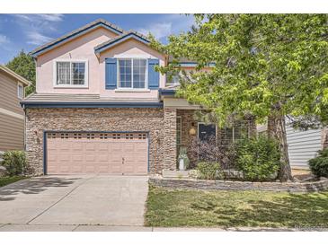 Charming two-story home with stone accents, a well-manicured lawn, and attractive exterior finishes at 1179 S Fultondale Cir, Aurora, CO 80018