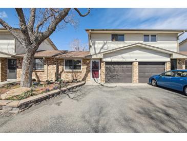 Charming townhome featuring a two-car garage, brick accents, and well-maintained landscaping at 4655 Independence St # 3, Wheat Ridge, CO 80033