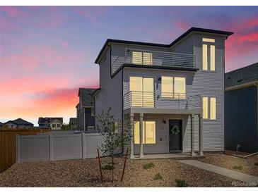 Charming two-story home with modern design, balcony, landscaped front yard, and a vibrant sunset at 5147 N Waco St, Denver, CO 80249