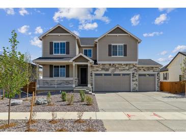 Inviting two-story home with stone accents, a three-car garage, and a charming front porch at 25214 E Warren Pl, Aurora, CO 80018