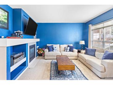 Bright living room featuring a cozy fireplace, plush sofas, and blue accent wall for a comfortable living space at 209 W Jamison Cir # 32, Littleton, CO 80120