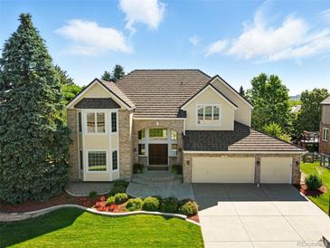 Stunning two-story home featuring a manicured lawn and a three-car garage at 9556 Kemper Dr, Lone Tree, CO 80124