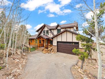 Stunning exterior of a multi-story home with a log cabin-style porch and attached garage at 11766 Coal Creek Heights Dr, Golden, CO 80403