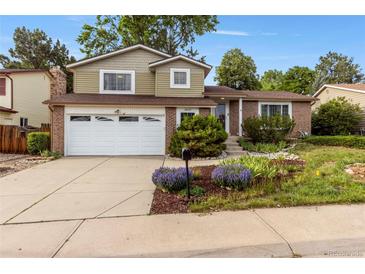 Charming brick and siding home featuring a two-car garage and beautifully landscaped front yard at 18625 E Kent Dr, Aurora, CO 80013