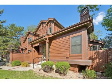 Charming townhouse featuring a wood exterior, landscaped yard, and inviting entryway on a sunny day at 9455 W 81St Ave # A, Arvada, CO 80005