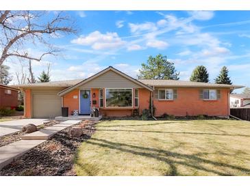 Charming brick home featuring a blue door, well-maintained lawn and attached garage on a beautiful day at 8276 E Easter Pl, Centennial, CO 80112