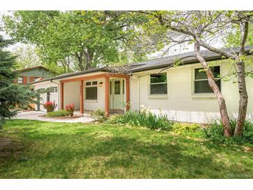 Inviting front yard with lush green grass and colorful landscaping, leading to the charming front entrance at 6891 W Eldorado Pl, Lakewood, CO 80227