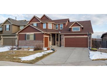 Two-story house with brown siding, brick accents, and a two-car garage at 4067 S Odessa St, Aurora, CO 80013