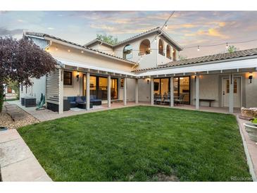Expansive backyard featuring a lush lawn, covered patio, and stylish outdoor seating, perfect for entertaining at 4525 King St, Denver, CO 80211