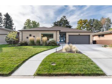 Ranch style home with landscaped lawn, attached garage, and modern facade at 6620 E Virginia Ave, Denver, CO 80224