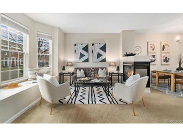 Cozy living room featuring a fireplace, stylish seating, and a bright bay window with a cushioned seat at 3974 W 118Th Pl, Westminster, CO 80031