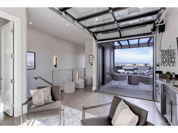 Contemporary living room that opens to a scenic rooftop deck, creating a seamless indoor-outdoor living experience at 2442 Champa St, Denver, CO 80205