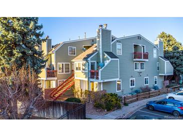 Inviting exterior of the townhome with red accents on the balcony railings and stair rails at 919 S Dawson Way # 7, Aurora, CO 80012