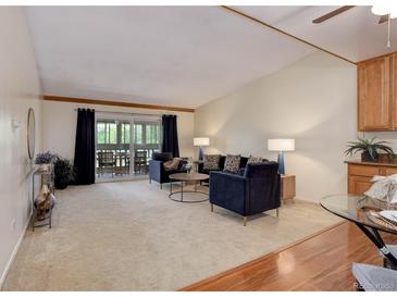 Cozy living room featuring plush seating and sliding door access to an outdoor balcony at 625 S Alton Way # 10D, Denver, CO 80247