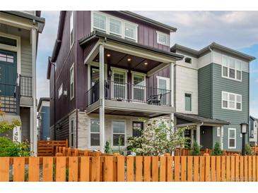 Charming two-story townhome with a balcony, fenced yard, and colorful siding at 14998 Cast Pebble Cir, Parker, CO 80134