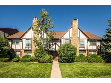 Charming townhouse exterior with brick chimney and well-maintained landscaping at 3855 S Monaco St # 208, Denver, CO 80237