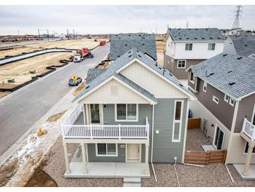 New construction two-story home with charming balcony and gray vinyl siding at 13615 E 103Rd Ave, Commerce City, CO 80022