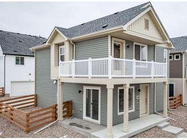 Charming two-story home with a second story balcony and neutral gray siding at 13615 E 103Rd Ave, Commerce City, CO 80022
