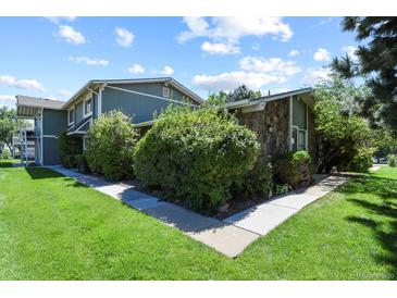 Charming townhome with lush landscaping, grassy lawn, and stone facade at 2246 N Coronado Pkwy # A, Denver, CO 80229