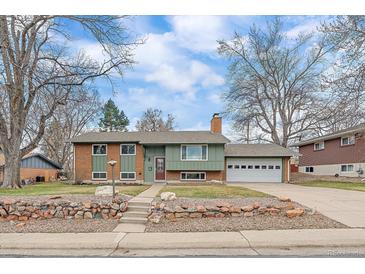 Charming ranch home featuring brick and siding, mature trees, and an attached two-car garage at 11972 W Dakota Dr, Lakewood, CO 80228