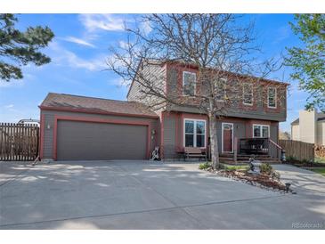 Charming two-story home with a spacious front yard and two car garage on a sunny day at 11321 N Brownstone Dr, Parker, CO 80138