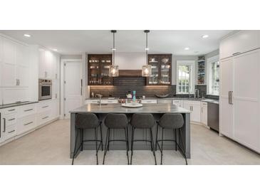 Modern kitchen features a large island with seating, stainless steel appliances, and stylish lighting at 18 Foxtail Cir, Englewood, CO 80113