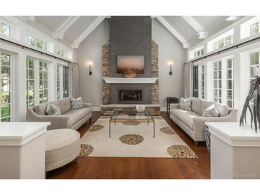 Bright living room features a stone fireplace, hardwood floors, and elegant decor at 18 Foxtail Cir, Englewood, CO 80113