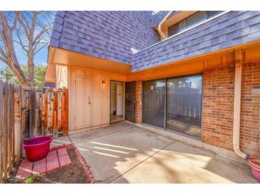 Private patio featuring brick accents, wood fence, and convenient access to sliding glass doors at 7995 E Mississippi Ave # C1, Denver, CO 80247