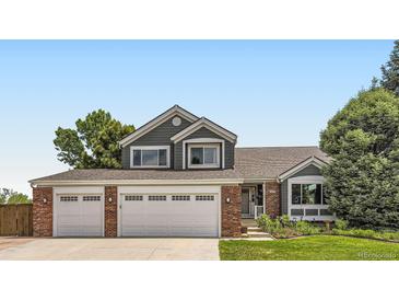 Charming two-story home with a well-manicured lawn, brick accents, and a two car garage at 9229 Sugarstone Cir, Highlands Ranch, CO 80130