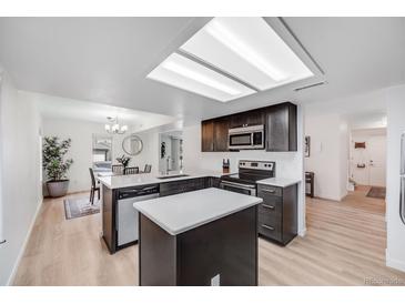 Modern kitchen features an island, stainless steel appliances, and sleek countertops at 6435 S Dayton St # 103, Englewood, CO 80111