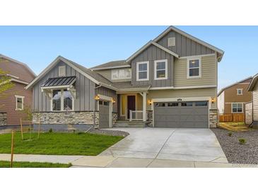 Charming two-story home featuring a well-manicured lawn, attached two-car garage, and stone accents at 4586 Windmill Dr, Brighton, CO 80601