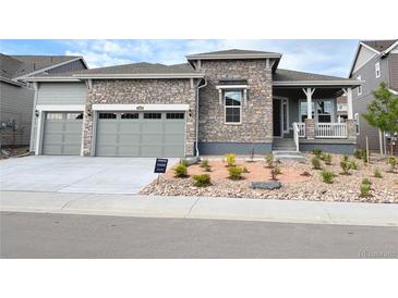 Beautiful stone and siding exterior with a well-manicured front yard and attached two car garage at 3966 Doubletrack Ln, Castle Rock, CO 80108