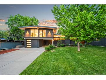 Contemporary two-story home featuring large windows, a well-manicured lawn, and an attached garage at 1440 S Dahlia St, Denver, CO 80222