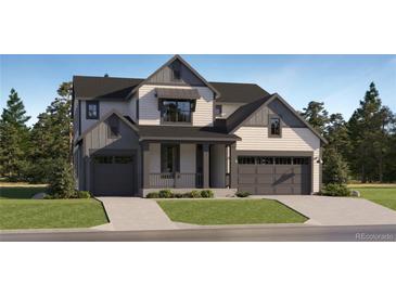 Beautiful two-story home featuring a covered porch, white siding, and a two-car garage on a lush landscaped lot at 39816 Floyd St, Elizabeth, CO 80107