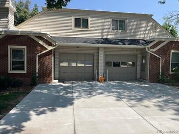 Home exterior featuring a two-car garage and classic brick and siding design at 1829 S Lee St # C, Lakewood, CO 80232