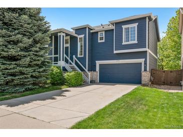 Charming two-story home with blue siding, white trim, well-manicured lawn, and an attached two-car garage at 104 Willowick Cir, Highlands Ranch, CO 80129